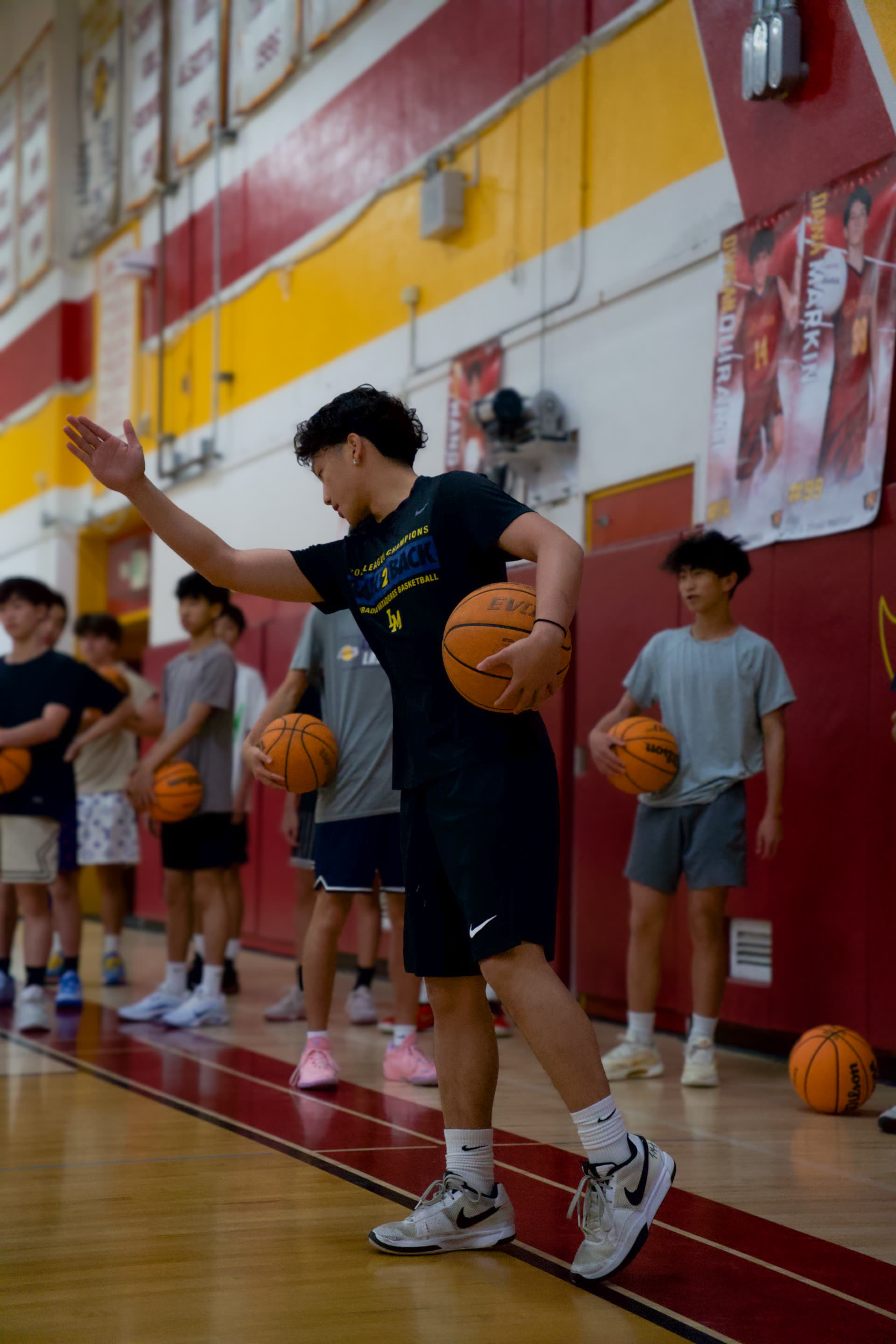 Coach Ethan Shigamora demonstrating a move to a line of players during a ShigHoops group session in Hacienda Heights